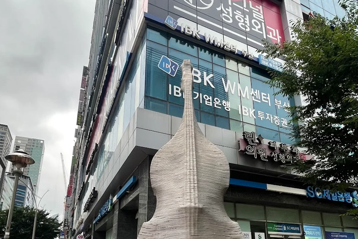 Exterior of Centum Imperial Tower, where Wannabe Clinic is located, showing a corner with a bank sign and a silver sculpture